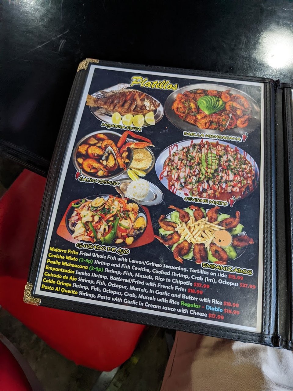 Printed menu pages with seafood, wings, and tacos.